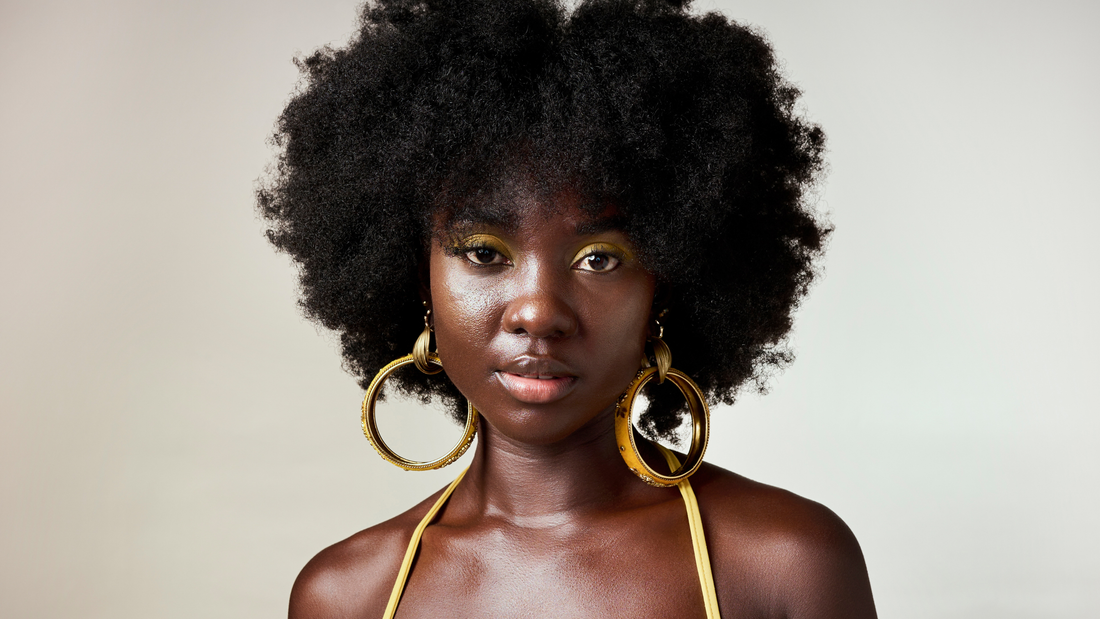 Young woman wearing large gold hoop earrings with a stylish outfit